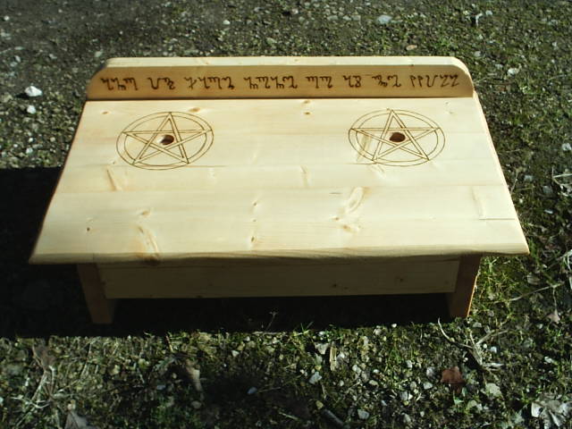 Two Pentacles surround candle holders and And It Harm None, Do As Ye Will is engraved on the backboard in Theban, the Witches Secret Language. And It Harm None, Do As Ye Will is a common Pagan verse, and is used often to symbolize a life of living with care for fellow persons, but without guilt of choice of our own destiny.