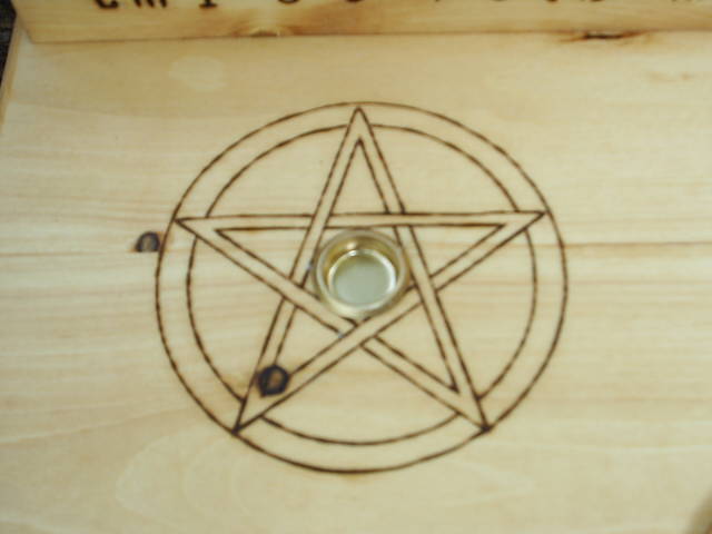 Two Candle Holders surrounded by wood-burned pentacles, and A Mounted Scrolled Pentagram in circle centered on table top of this Wooden Altar