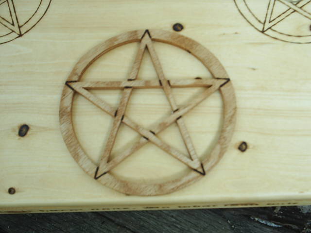 Two Candle Holders surrounded by wood-burned pentacles, and A Mounted Scrolled Pentagram in circle centered on table top of this Wooden Altar