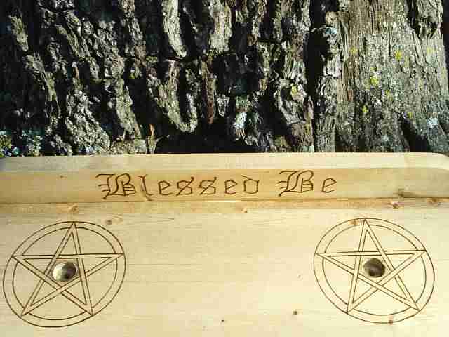 Two Pentacles surround candle holders and Blessed Be is engraved on the backboard.<br><br> Blessed Be is a common Pagan verse, and is used often in the parting of two or more Wiccans, in place of good-bye<border=